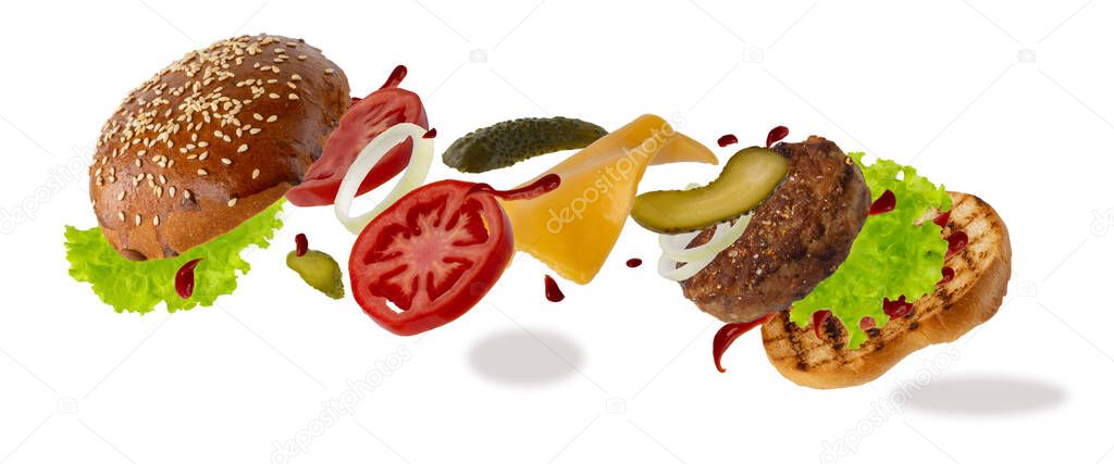 Delicious burger with flying ingredients isolated on white background. Food levitation concept. classic burger, assembled sandwich. preparing a quick meal, fast food products. copy space.