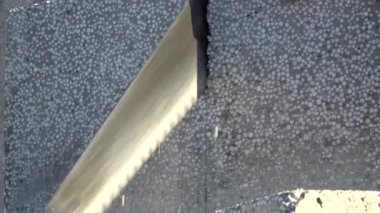 Köpük beton bir bloğu testereyle kesmek. Bloklar doğal maddelerden yapılmış ve çevre dostu. Kendi evini inşa etme kavramı