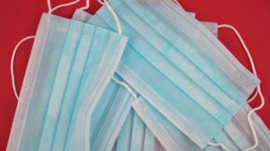 Koronavirüse karşı korunmak için antiviral tıbbi maske. Cerrahi koruyucu maske. Kırmızı arka planda tıbbi solunum bandajı var.. 