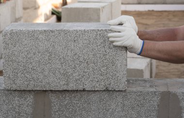 Adam taş bloklar yerleştiriyor, bir ev inşa ediyor. Boşluğu kopyala