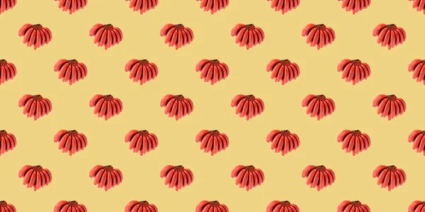 pattern of bananas. fresh red banana isolated on yellow background. group of varieties of banana with reddish-purple skin. Musa acuminata Red Dacca. variety contains more beta carotene and vitamin C