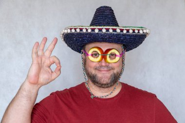 Meyve bardakları. Elmadan yapılmış gözlüklü komik adam. Adam zafer işareti gösteriyor. İspanyol ya da Meksikalı sombrero giyiyor..