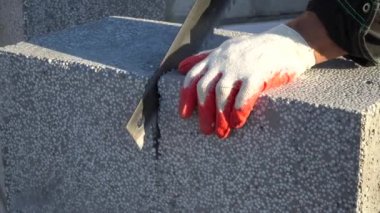 Köpük beton bir bloğu testereyle kesmek. Bloklar doğal maddelerden yapılmış ve çevre dostu. Kendi evini inşa etme kavramı