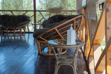 Rahat koltukları olan oturma alanı ve antibakteriyel maddesi olan bir kap. Salgın bağlamında yeniden canlandırma. Antiseptik ile dinlenme alanlarının tedavisi