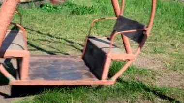 Çocuklar için eski metal salıncak. Atlıkarınca hareket ediyor. Oyun parkı olan terk edilmiş bir şehir. Boş salıncak, çocuk kaçırma kavramı. Adam kaçırma.