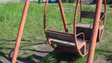 Çocuklar için eski metal salıncak. Atlıkarınca hareket ediyor. Oyun parkı olan terk edilmiş bir şehir. boş vuruş, 