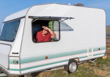 Adam bir seyahat karavanıyla rahatlıyor. Gezginlerin konforunu sağlamak için gerekli tüm ev aletleriyle donatılmış büyük ölçekli karavan karavanı.