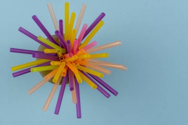 Mor arkaplanlı ve fotokopi alanı olan yaz kokteylleri için renkli pipetler. Üst Manzara. Kamış Günü, 3 Ocak.