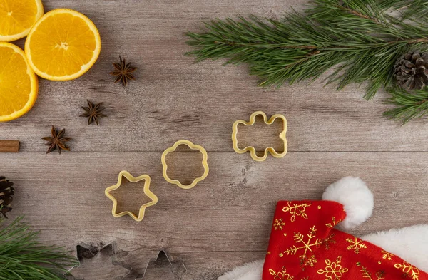preparing festive treats for Christmas and new year holidays. cookie molds and flour. orange and star anise. fir branches and cones. flat layout