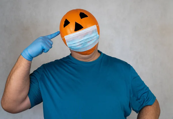 医療用呼吸器包帯の顔にハロウィンカボチャ 外科用保護マスク オレンジの悪マスクの人 バスケットボールからジャックランタンマスク 隔離期間中のハロウィーンを祝う — ストック写真