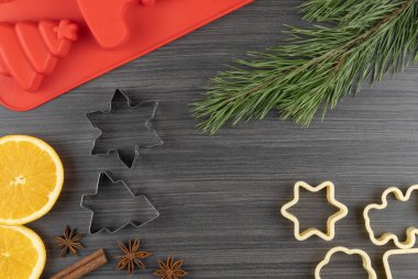 Noel ve yeni yıl tatili için ziyafet hazırlıyorum. Kurabiye kalıpları, portakal ve yıldız anason. Köknar dalları ve koniler. düz yerleşim