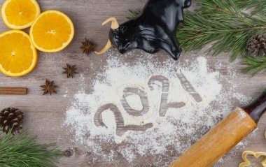 Noel ve yeni yıl tatili için ziyafet hazırlıyorum. Takvim, yeni yıl 2021 düz planının sembolü olarak 31 Ocak tarihli boğa. Kurabiye kalıpları ve un. turuncu ve yıldız anason.