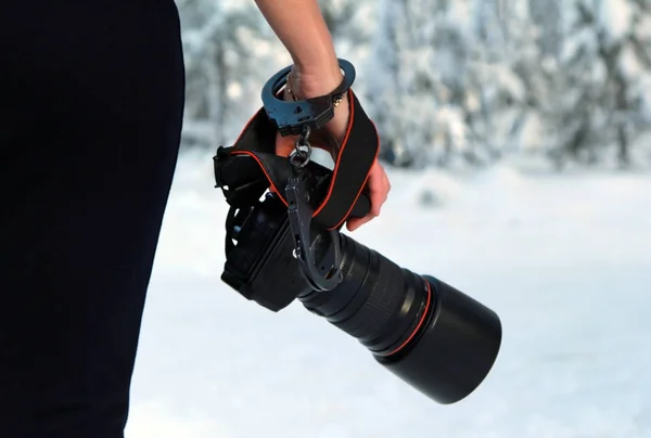 Elinde kamera olan kız. Kelepçe ile tutturulmuş.