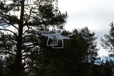 Orman ve bulutlar arka planda quadcopter. Arka planda orman, bulutlar ve ağaçlar vardır.