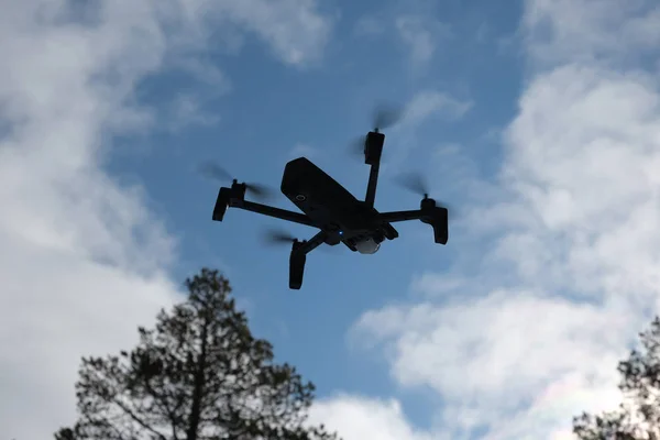 Orman ve bulutlar arka planda quadcopter. Arka planda orman, bulutlar ve ağaçlar vardır.