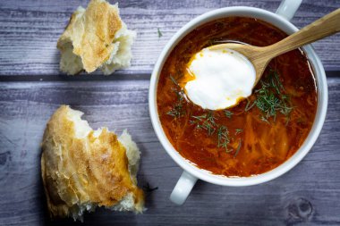 Tahta kaşıkla beyaz bir bardakta çorba. Th arka planda