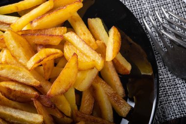 Siyah tabakta patates kızartması. Panoların arka planı.