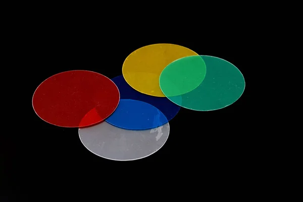 Color circles, light filters on a black background.