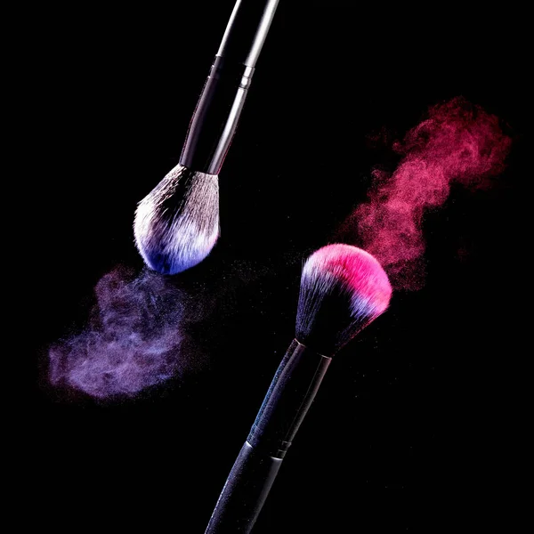 Siyah arka plan üzerinde makyaj için siyah arka plan fırçaları üzerinde toz Sıçrama.