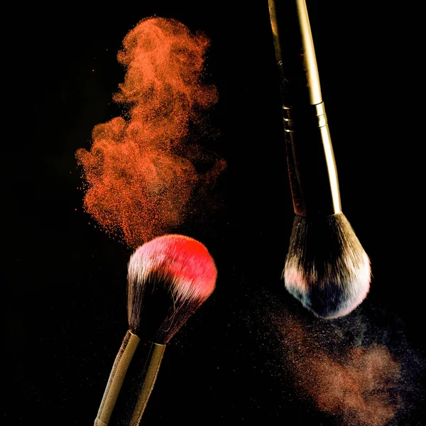 Siyah arka plan üzerinde makyaj için siyah arka plan fırçaları üzerinde toz Sıçrama.