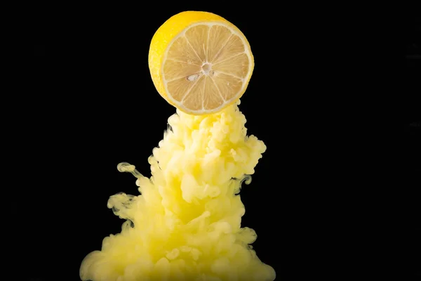 Siyah arka planda dilim üzerine sıçrayan portakal suyu