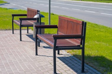 Bir şehir parkında dinlenme ve çöp kutusu için ahşap tezgah.