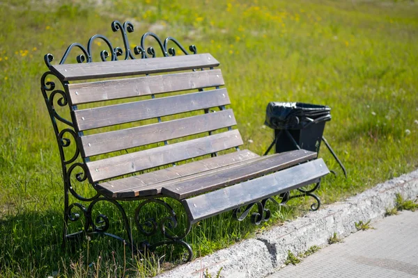 Деревянная скамейка для отдыха и мусорное ведро в городском парке . — стоковое фото