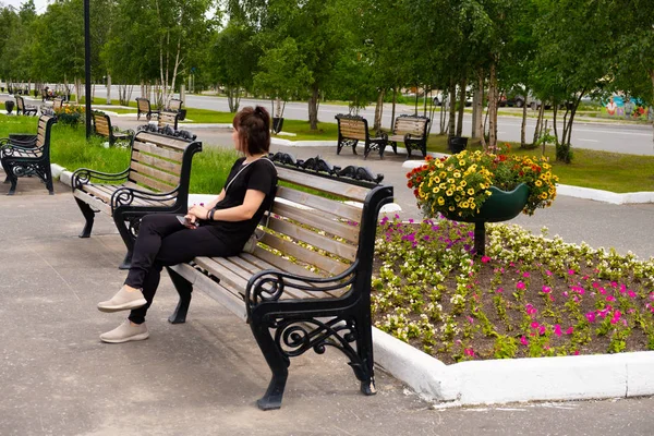 Девушка сидит на скамейке в парке. Святой день . — стоковое фото
