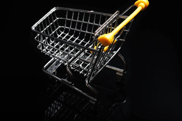 Close-up de carrinhos de compras em fundo preto Trolley, conceito de venda carrinho de compras de supermercado vazio. Isolado sobre fundo preto . — Fotografia de Stock