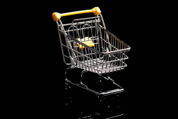 黒い背景トロリー上のショッピングカートのクローズアップ, 販売コンセプト空の食料品のショッピングカート.黒い背景の上に隔離. — ストック写真
