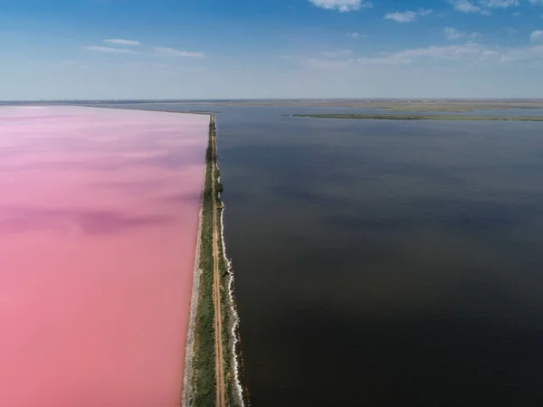 El lago rosa. Tomado de la vista de un pájaro. El lago oscuro y rosado está separado por un camino de tierra . — Foto de Stock