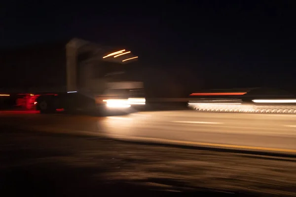 Bir hız yolunda bulanık araba parçaları ile soyut görüntü. Arabalar gece hızlı hareket eder. Yüksek hızda araba ile bulanık ışıklar