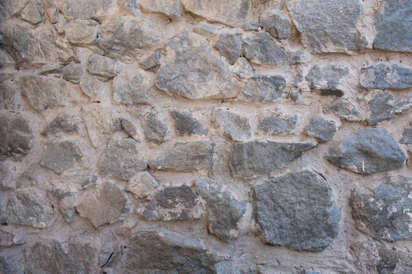 Achtergrond van natuursteen. Grote delen van de muur worden overspoeld met beton. Grijze stenen muur achtergrond. — Stockfoto