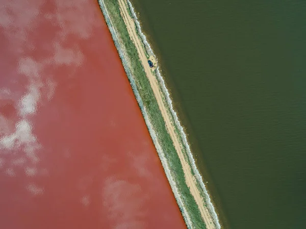 Rosa See sasyk sivash. die Straße, die die Küste trennt. aus der Drohne. Stockbild