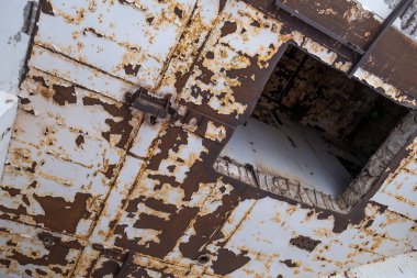 Interior of an old abandoned building with traces of rust on the walls.