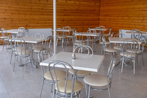 Chromed tables and chairs against the background of a wall made of wood. — ストック写真