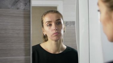 kız yüzünde sivilce ile bir banyo ayna tarafından