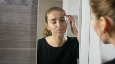 kız yüzünde sivilce ile bir banyo ayna tarafından