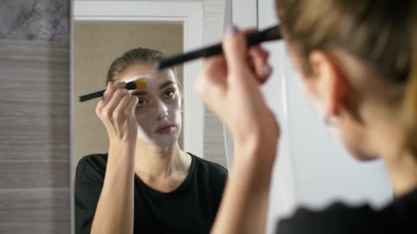 Fille avec de l'acné sur le visage est une salle de bain par le miroir — Video