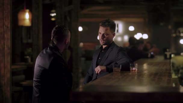 Twee mannen in kostuums drink whisky in een bar — Stockvideo