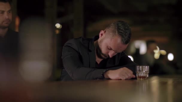 Двое мужчин в костюмах пьют виски в баре — стоковое видео