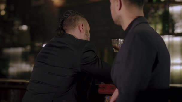 Zwei Männer in Anzügen trinken Whisky in einer Bar — Stockvideo