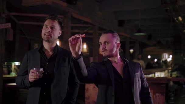 Δύο άντρες με κοστούμια πίνουν ουίσκι σε ένα μπαρ — Αρχείο Βίντεο