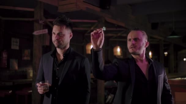 Dos hombres en trajes beben whisky en un bar — Vídeo de stock