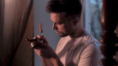 Evdeki adam antikalarının restorasyonunu yapıyor.