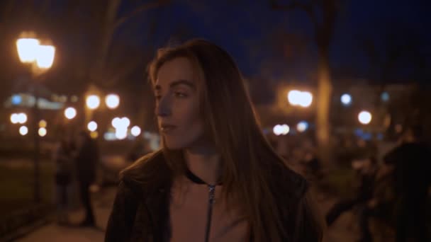 Дівчина гуляє вночі в місті — стокове відео
