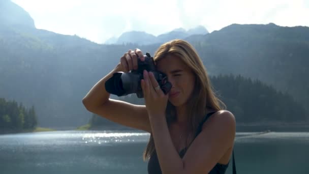 Meisje neemt een foto staat tegen de achtergrond van het landschap. — Stockvideo