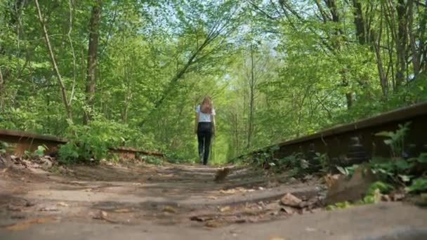 Chica caminando a lo largo de los viejos carriles — Vídeo de stock