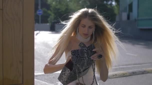Moda menina rummaging em sua bolsa — Vídeo de Stock