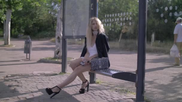 Chica de moda en la parada de autobús — Vídeo de stock